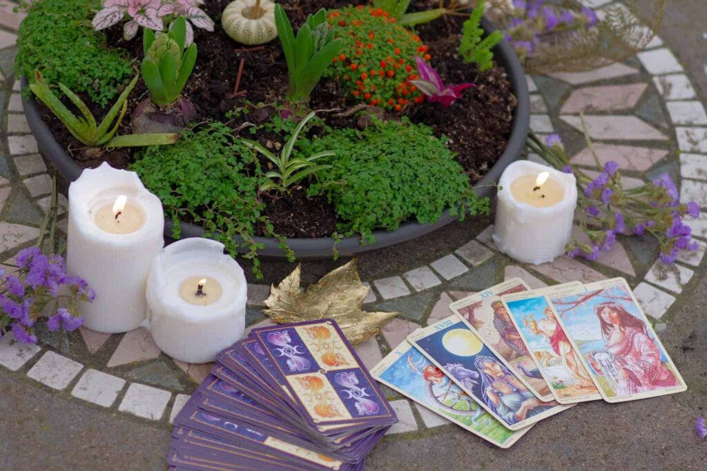 a table topped with candles and cards next to a potted plant, witches, Wicca, pagan
