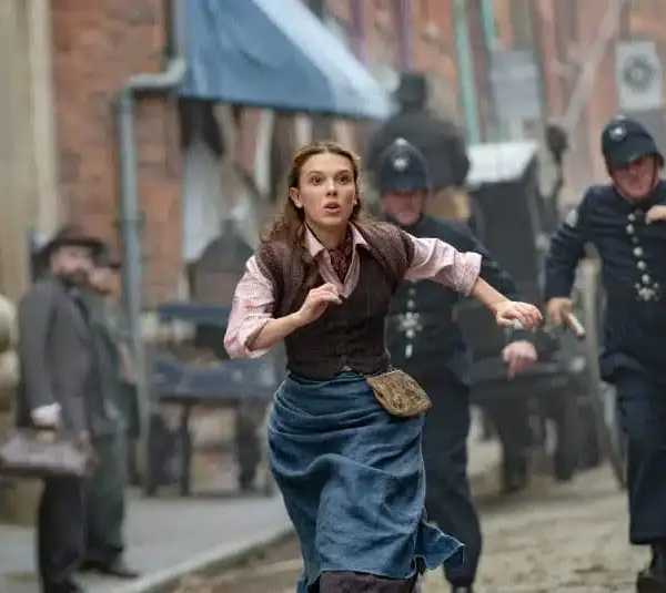 Millie Bobbie Brown as Enola Holmes running through the streets.