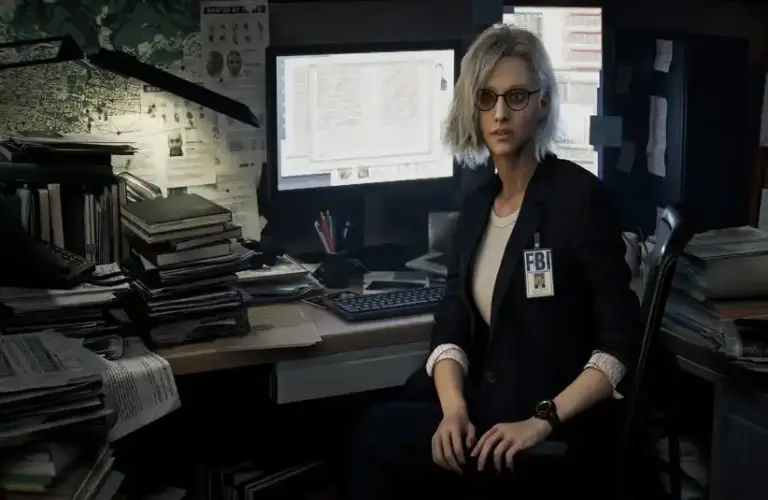 Resident Evil Requiem Grace Ashcroft sits at her desk and faces away from her computer there are multiple folders and documents on the desk