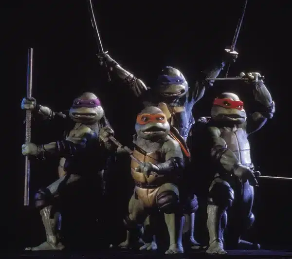 The Teenage Mutant Ninja Turtles are posing in front of a black background.