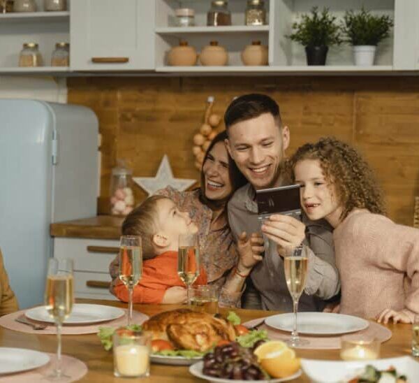 This photograph features a family having festive dinner together. The holidays can be a time of productive discussion about ways to co-parent.