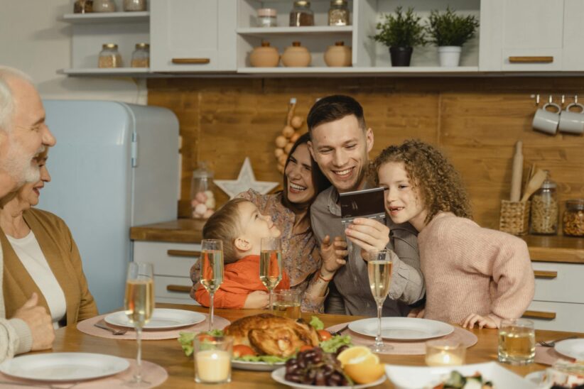 This photograph features a family having festive dinner together. The holidays can be a time of productive discussion about ways to co-parent.