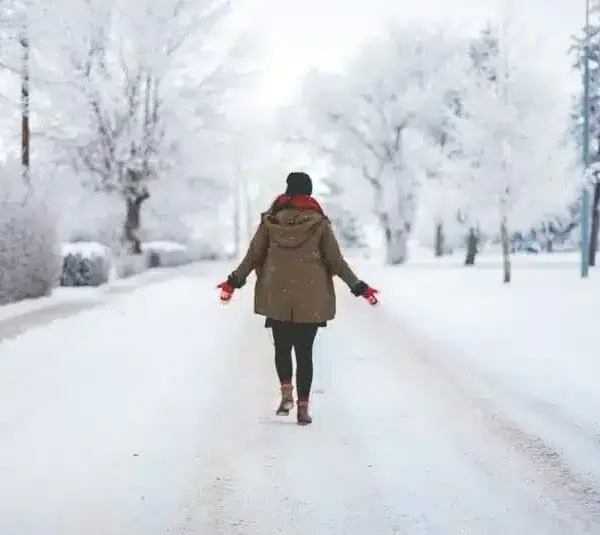 Person walking on a snowy street, winter walking