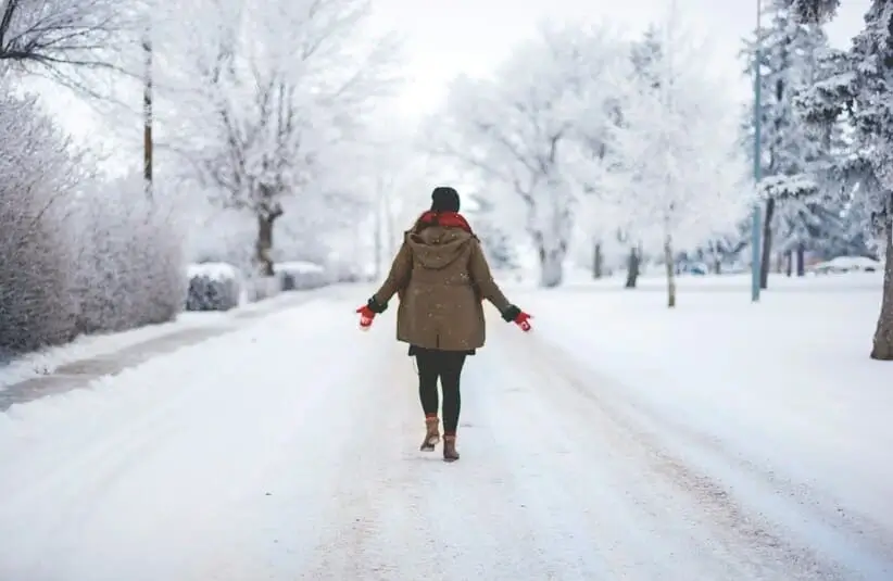 Person walking on a snowy street, winter walking