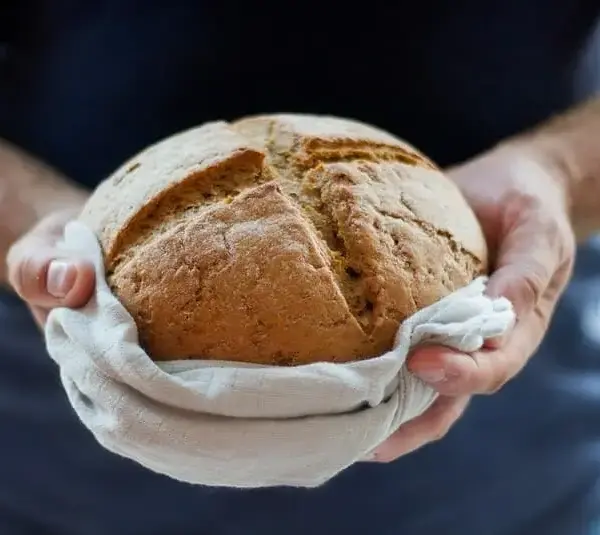 Man holding bread in a giving gesture, churches, holiday outreach, gluten-free, thanksgiving