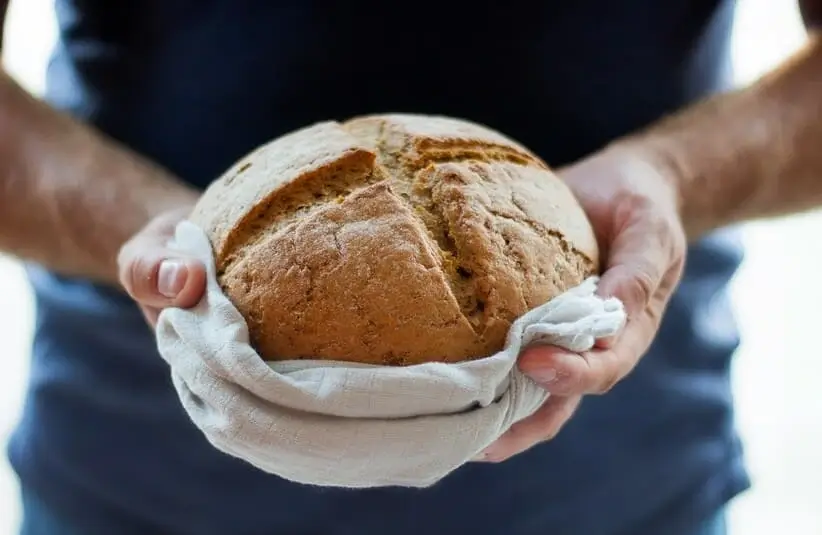 Man holding bread in a giving gesture, churches, holiday outreach