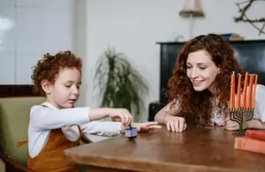 boy playing with a dreidel, Jewish holiday traditions like Hanukkah