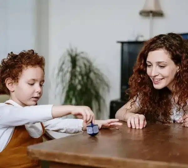 boy playing with a dreidel, Jewish holiday traditions like Hanukkah