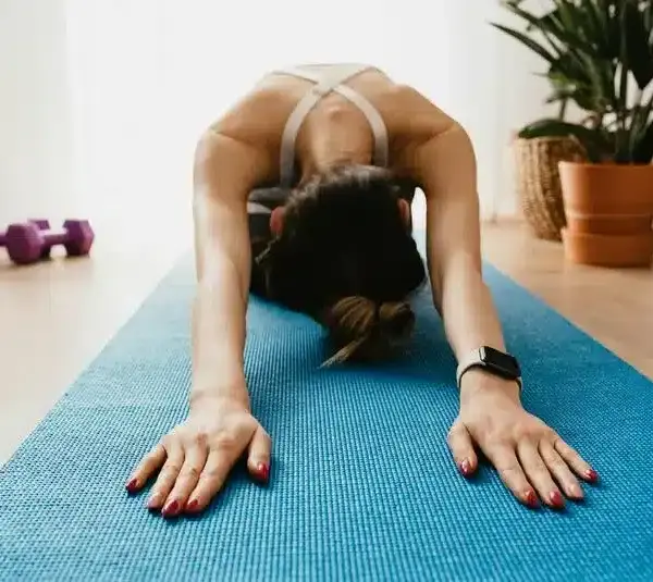 Woman stretching on a yoga mat. Yoga can be one of the great low-impact workouts for winter fitness routines.