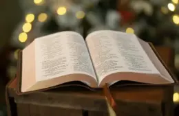 open bible with blurred christmas lights in the background. Keeping Christ in Christmas. daily devotion