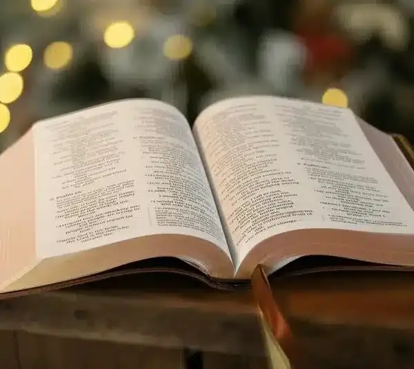 open bible with blurred christmas lights in the background. Keeping Christ in Christmas. daily devotion
