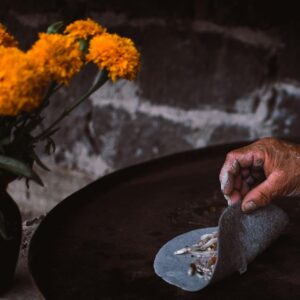 Close-up of hands preparing blue corn tlacoyos on a griddle, Janitzio, México. Traditional Native American ingredients, and love.
