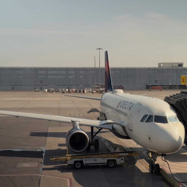 A Delta airplane docked at Montreal's airport gate 84 during daylight. Voted best u.s. airline.