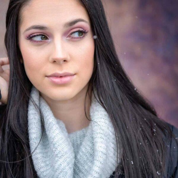 This is a photograph of a woman in a gentle snowfall. Makeup essentials focusing on taking care of skin can help you sparkle in winter.