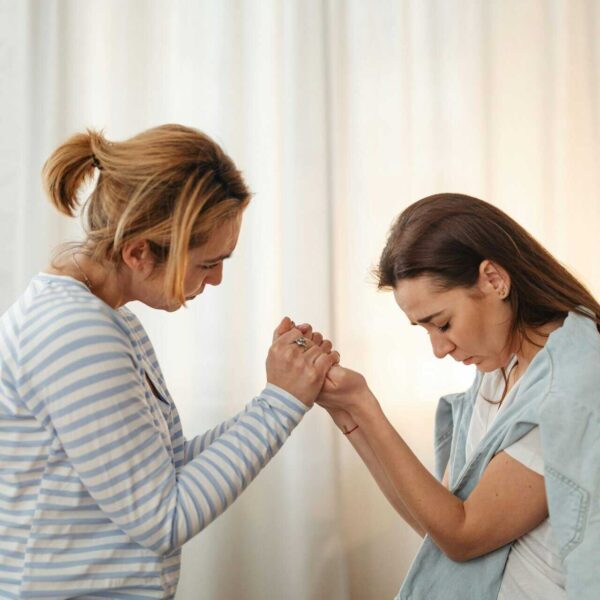 Two women sharing a moment of support and empathy indoors.