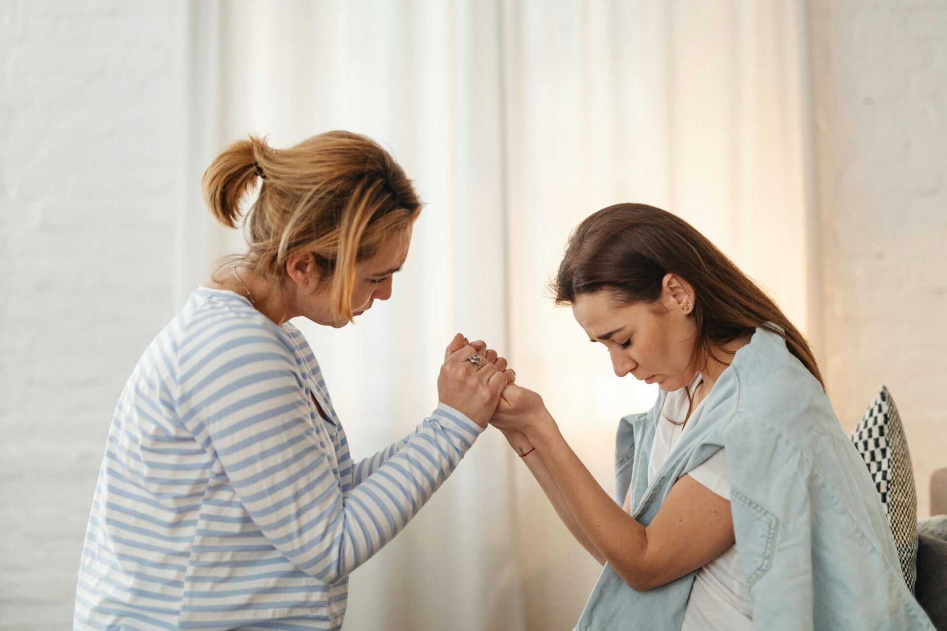 Two women sharing a moment of support and empathy indoors.