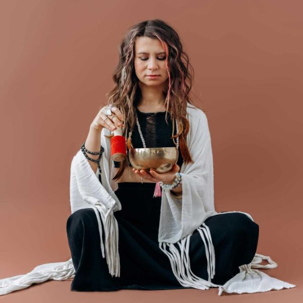 A serene woman meditates with a singing bowl, evoking a sense of peace and balance, Native American, wellness