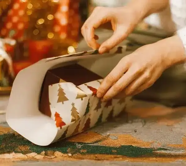 A person wrapping a gift, low-cost gift ideas for the holidays