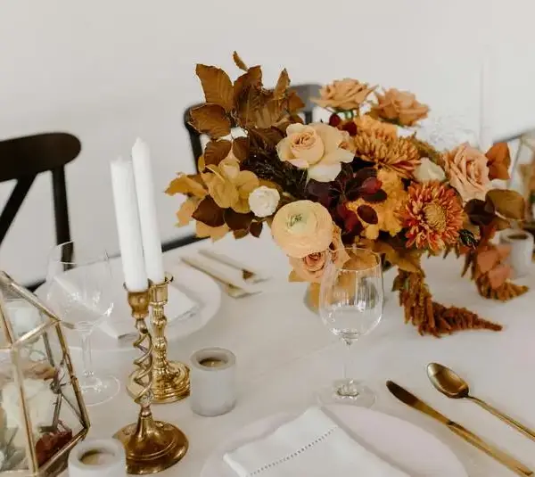 banquet table decorated with candles and flowers.This can be a great option for DIY Fall centerpieces.