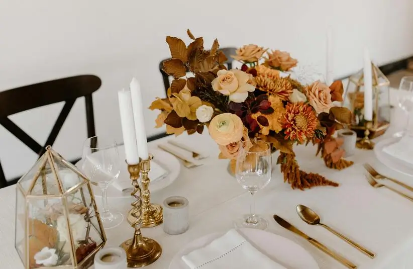 banquet table decorated with candles and flowers.This can be a great option for DIY Fall centerpieces.