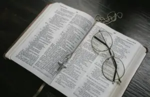 a close up picture of an open bible. your daily devotion.