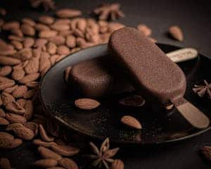 Rich almond and chocolate ice cream bars on a dark plate with whole almonds. Häagen-Dazs, recall on ice cream bars.