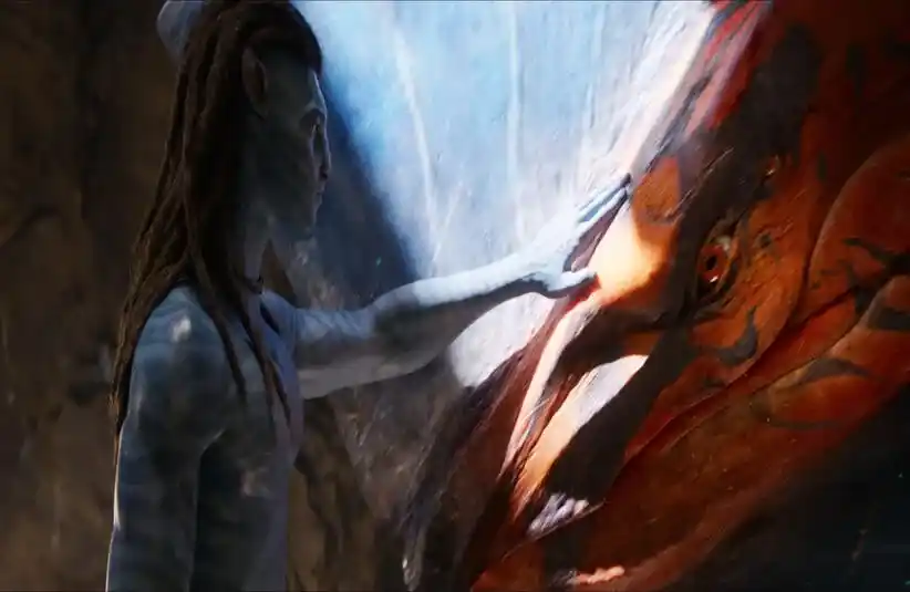Sam Worthington in Avatar: Fire and Ash petting a dragon