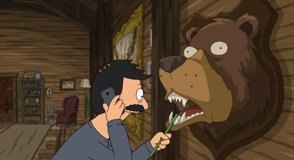A man with a mustache brushes the teeth of a bear head mounted on a wooden wall while talking on the phone. The room has rustic decor and a cozy atmosphere.
