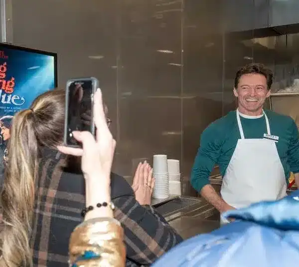 Actor Hugh Jackman, right, greets Rachel Cartwright, left, daughter of Claire Sardina, before he serves a special flavor of the day, Song Sung Blueberry, at Kopp's Frozen Custard as part of the Milwaukee premiere of “Song Sung Blue” on Tuesday December 2, 2025 in Greenfield, Wisconsin.