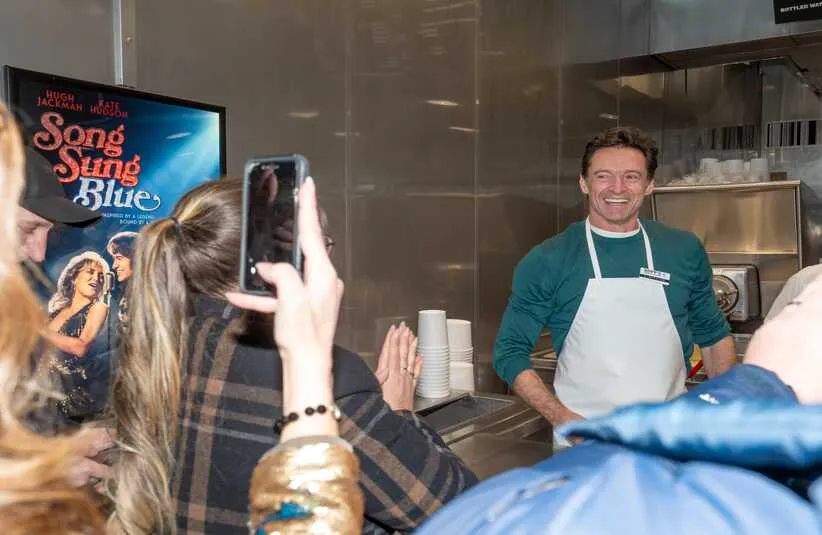 Actor Hugh Jackman, right, greets Rachel Cartwright, left, daughter of Claire Sardina, before he serves a special flavor of the day, Song Sung Blueberry, at Kopp's Frozen Custard as part of the Milwaukee premiere of “Song Sung Blue” on Tuesday December 2, 2025 in Greenfield, Wisconsin.