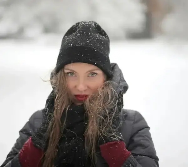 woman in black knit hat outdoors in the snow, winter outfit