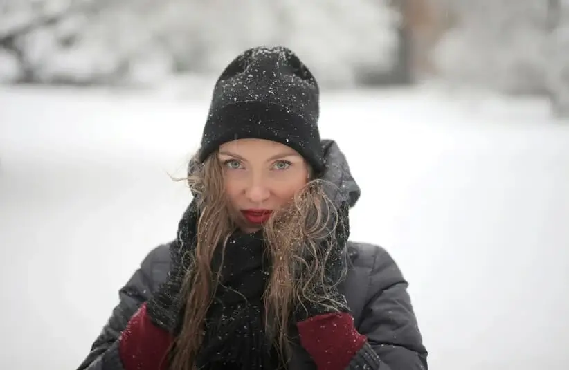 woman in black knit hat outdoors in the snow, winter outfit