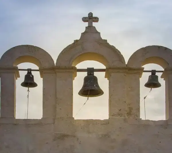 Three bells framed by arches, above a church on the island of Comino, Malta., Saint Paulinus