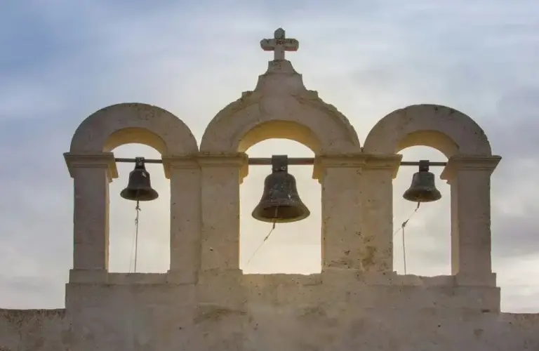 Three bells framed by arches, above a church on the island of Comino, Malta., Saint Paulinus