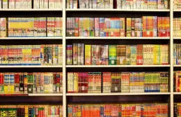 Bookshelf lined with colorful manga volumes in Japanese, organized neatly in rows. Vibrant covers create a lively and inviting atmosphere. Free Comic Book Day 2026