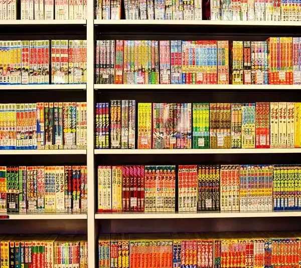 Bookshelf lined with colorful manga volumes in Japanese, organized neatly in rows. Vibrant covers create a lively and inviting atmosphere. Free Comic Book Day 2026
