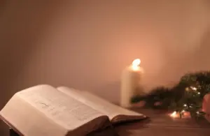 Bible open on a table with a candle beside it, Daily Devotion, candlelight