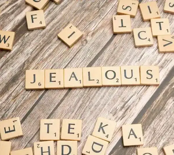 Jealous spelled out in scrabble like tiles. Holiday jealousy can be a lot to navigate