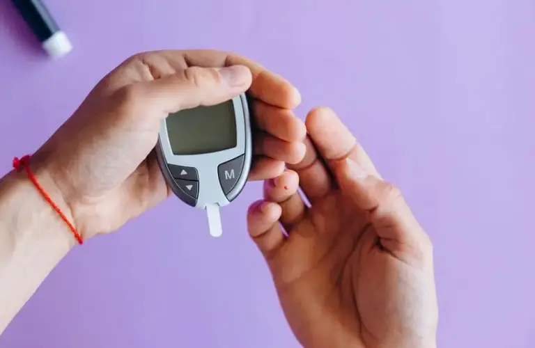 Person holding a glucose meter. There is a problem with many glucose monitors right now.