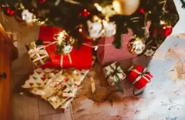 Video Games, as a Christmas Tradition, wrapped in red and festive paper, are placed under a decorated tree.