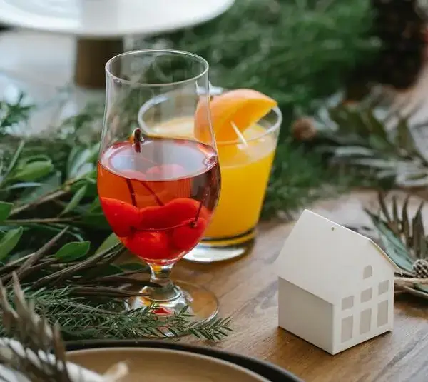 Glasses of tasty cocktails on a table with Christmas decor. These can be some great seasonal cocktails., non-alcoholic drinks