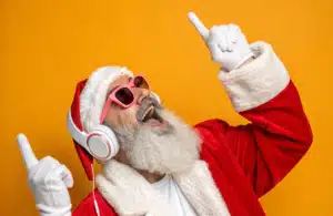 Santa Claus is listening to Christmas Songs with headphones on.