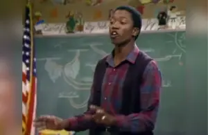 T.K. Carter in a plaid shirt is speaking passionately in front of a chalkboard with diagrams during an episode of "Punky Brewster" called "The Search" (1984).