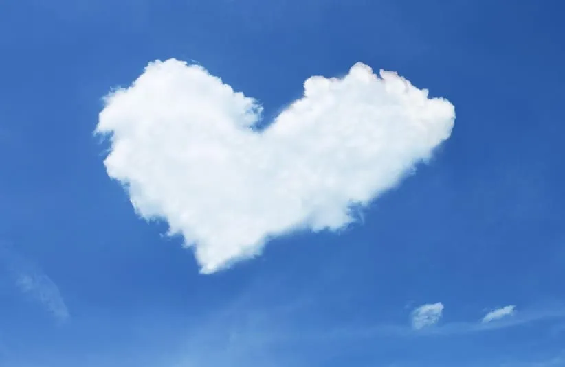 image of A fluffy white cloud shaped like a heart floats against a clear blue sky, evoking a sense of calmness, whimsy, and Valentine's Day
