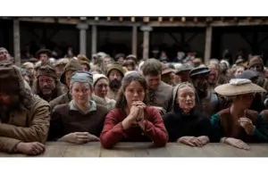 Jessie Buckley as Agnes, watching a Shakespeare play in Hamnet, which is nominated for sux Golden Globes.