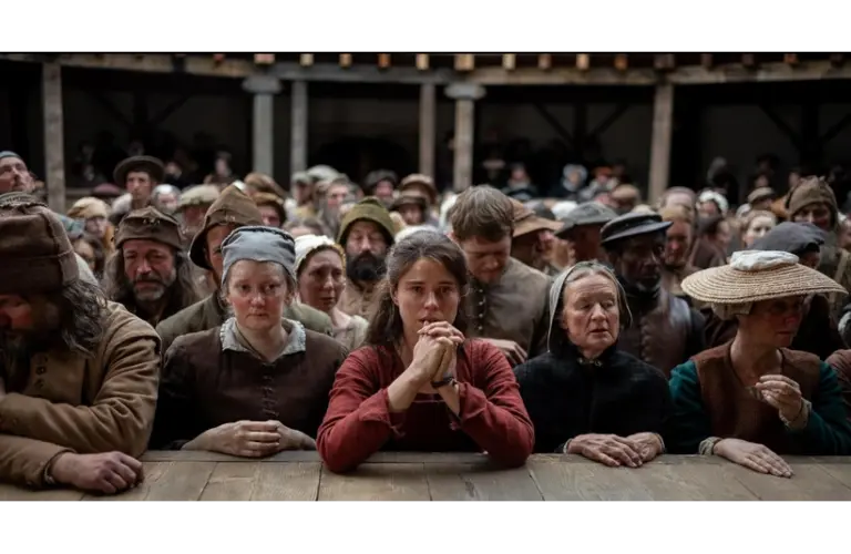 Jessie Buckley as Agnes, watching a Shakespeare play in Hamnet, which is nominated for sux Golden Globes.