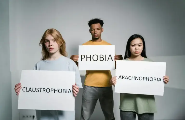 Three people hold signs with the words representing Mental and emotional health