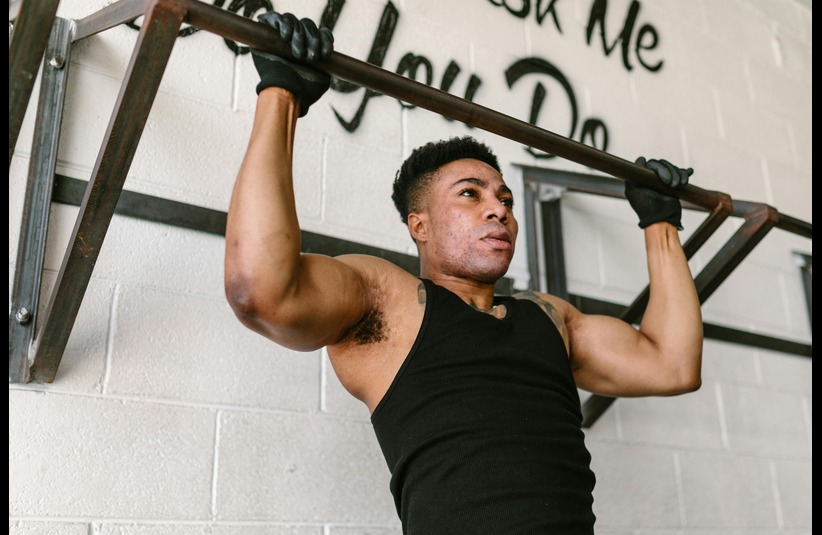 A man concentrating as he does push ups on bar bell