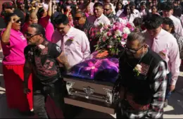 Pallbearers bring in the casket carrying Emily Pike.
