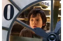 Best steampunk films - “Hugo” - image of Asa Butterfield examining an automaton clock